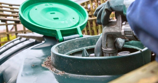 Nozzle placed into oil tank for refill